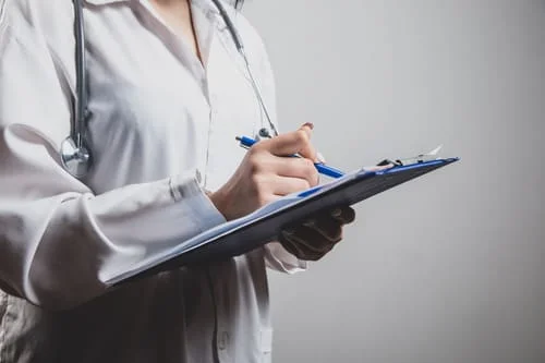 врач записывает рекомендации после лечения ПТСР